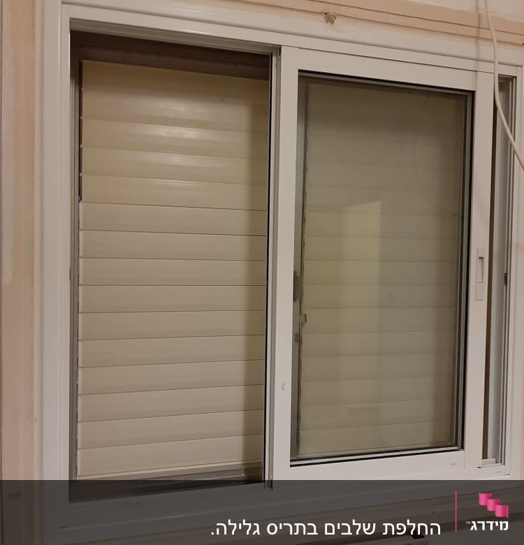 חלון עם תריסים סגורים בצבע לבן